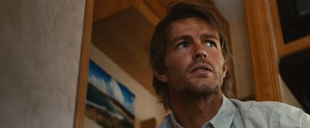 Movie still from “Run & Gun” (2022), directed by Christopher Borrelli – A person looking up at the sky; Close Up shot, Low angle