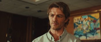 Movie still from “Run & Gun” (2022), directed by Christopher Borrelli – A person with long hair; Close Up shot, Over the shoulder angle