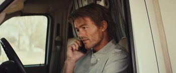 Movie still from “Run & Gun” (2022), directed by Christopher Borrelli – A person talking on a cell phone; Close Up shot, Over the shoulder angle