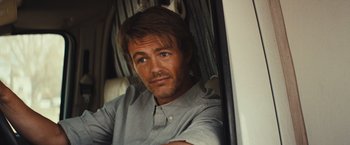 Movie still from “Run & Gun” (2022), directed by Christopher Borrelli – A person sitting in a vehicle; Close Up shot, Over the shoulder angle