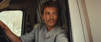 Movie still from “Run & Gun” (2022), directed by Christopher Borrelli – A person wearing a gray shirt; Close Up shot, Over the shoulder angle