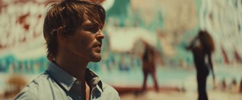 Movie still from “Run & Gun” (2022), directed by Christopher Borrelli – A person wearing a white shirt; Close Up shot, Low angle