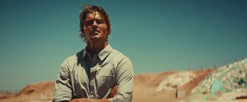 Movie still from “Run & Gun” (2022), directed by Christopher Borrelli – A person standing in a field; Close Up shot, Low angle