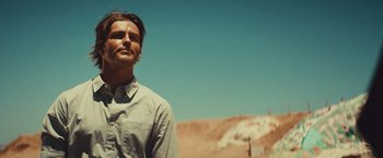 Movie still from “Run & Gun” (2022), directed by Christopher Borrelli – A man standing on a dirt road in the desert; Close Up shot, Low angle