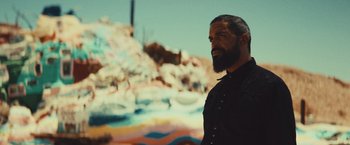Movie still from “Run & Gun” (2022), directed by Christopher Borrelli – A man with a beard standing in front of a waterfall; Close Up shot, Low angle