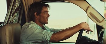 Movie still from “Run & Gun” (2022), directed by Christopher Borrelli – A person driving a car; Close Up shot, Over the shoulder angle