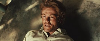 Movie still from “Run & Gun” (2022), directed by Christopher Borrelli – A person wearing a white shirt; Close Up shot, Low angle