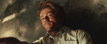 Movie still from “Run & Gun” (2022), directed by Christopher Borrelli – A person wearing a white shirt; Close Up shot, Low angle