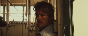 Movie still from “Run & Gun” (2022), directed by Christopher Borrelli – A person wearing a white shirt; Close Up shot, Over the shoulder angle