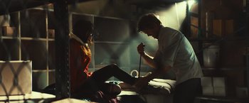 Movie still from “Run & Gun” (2022), directed by Christopher Borrelli – A man and a woman sitting on a bed; Wide shot, Low angle