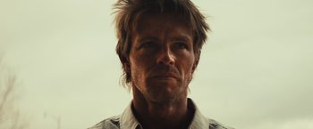 Movie still from “Run & Gun” (2022), directed by Christopher Borrelli – A person wearing a white shirt; Close Up shot, Low angle