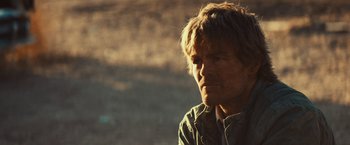 Movie still from “Run & Gun” (2022), directed by Christopher Borrelli – A person wearing a shirt; Close Up shot, Over the shoulder angle