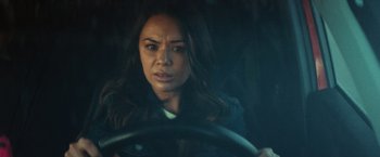 Movie still from “Run & Gun” (2022), directed by Christopher Borrelli – A woman sitting in the drivers seat of a car; Close Up shot, Over the shoulder angle