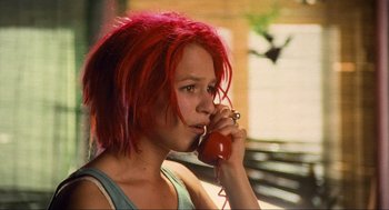 Movie still from “Run Lola Run” (1998), directed by Tom Tykwer – A woman with red hair talking on a red phone; Close Up shot, Low angle