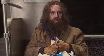 Movie still from “Run Lola Run” (1998), directed by Tom Tykwer – A man with long hair and a beard holding a cat; Medium shot, Low angle