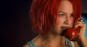Movie still from “Run Lola Run” (1998), directed by Tom Tykwer – A woman with red hair is looking to her left; Close Up shot, Low angle