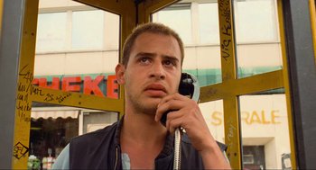 Movie still from “Run Lola Run” (1998), directed by Tom Tykwer – A man holding a phone up to his ear; Close Up shot, Low angle