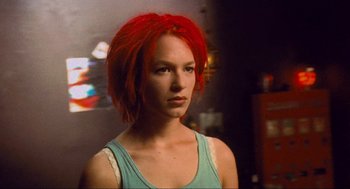 Movie still from “Run Lola Run” (1998), directed by Tom Tykwer – A woman with red hair is looking at the camera; Close Up shot, Low angle