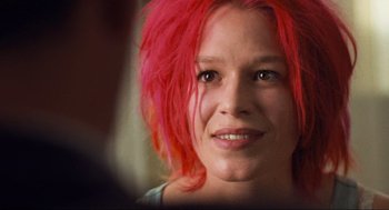 Movie still from “Run Lola Run” (1998), directed by Tom Tykwer – A person with pink hair; Close Up shot, Over the shoulder angle