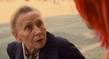 Movie still from “Run Lola Run” (1998), directed by Tom Tykwer – An old woman sitting on the ground looking at the camera; Close Up shot, Over the shoulder angle