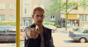 Movie still from “Run Lola Run” (1998), directed by Tom Tykwer – A man holding a gun in his right hand; Close Up shot, Over the shoulder angle