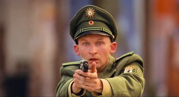 Movie still from “Run Lola Run” (1998), directed by Tom Tykwer – A man in a military uniform holding a gun; Close Up shot, Low angle