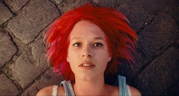 Movie still from “Run Lola Run” (1998), directed by Tom Tykwer – A woman with red hair is laying on the ground; Close Up shot, Overhead angle