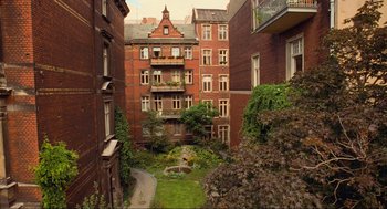 Movie still from “Run Lola Run” (1998), directed by Tom Tykwer – A courtyard in a residential area of a city; Extreme Wide shot, High angle