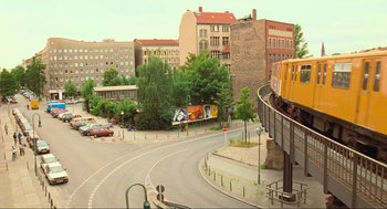Movie still from “Run Lola Run” (1998), directed by Tom Tykwer – A yellow train traveling down the tracks in a city; Extreme Wide shot, High angle