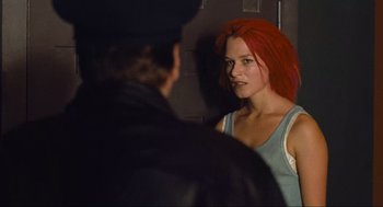 Movie still from “Run Lola Run” (1998), directed by Tom Tykwer – A woman with red hair looking into a mirror; Medium shot, Over the shoulder angle