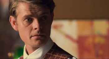 Movie still from “Run Lola Run” (1998), directed by Tom Tykwer – A person wearing a suit and tie; Close Up shot, Over the shoulder angle