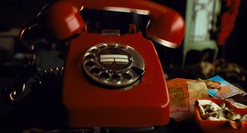 Movie still from “Run Lola Run” (1998), directed by Tom Tykwer – An old red telephone with a silver dial; Extreme Close Up shot, Overhead angle