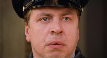 Movie still from “Run Lola Run” (1998), directed by Tom Tykwer – A man wearing a police uniform; Close Up shot, Low angle