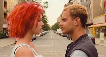 Movie still from “Run Lola Run” (1998), directed by Tom Tykwer – A man and a woman standing next to each other on a street; Close Up shot, Low angle