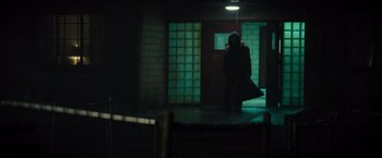 Movie still from “Samaritan” (2022), directed by Julius Avery – A person standing in a dark room holding a bag; Wide shot, Over the shoulder angle