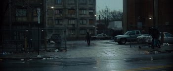Movie still from “Samaritan” (2022), directed by Julius Avery – A person is walking down the street in the rain; Extreme Wide shot, Low angle