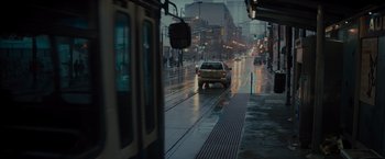 Movie still from “Samaritan” (2022), directed by Julius Avery – A car is driving down the street on a rainy day; Extreme Wide shot, High angle