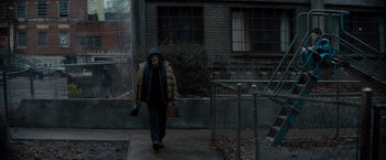 Movie still from “Samaritan” (2022), directed by Julius Avery – An older woman walking down a sidewalk with a purse; Wide shot, High angle