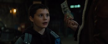 Movie still from “Samaritan” (2022), directed by Julius Avery – A young boy holding a $ 2 0 bill in his hand; Close Up shot, Over the shoulder angle