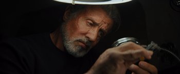Movie still from “Samaritan” (2022), directed by Julius Avery – An older man looking at a jar in the dark; Close Up shot, Low angle