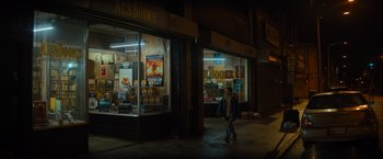 Movie still from “Samaritan” (2022), directed by Julius Avery – A person walking down the sidewalk in front of a bookstore; Extreme Wide shot, High angle