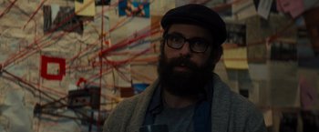 Movie still from “Samaritan” (2022), directed by Julius Avery – A man with a goatee wearing glasses and a hat; Close Up shot, Over the shoulder angle