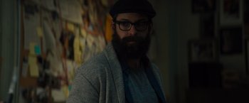 Movie still from “Samaritan” (2022), directed by Julius Avery – A man with a beard wearing glasses and a hat; Close Up shot, Over the shoulder angle