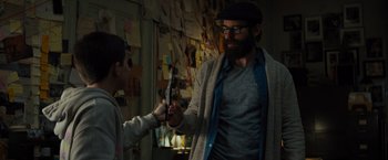 Movie still from “Samaritan” (2022), directed by Julius Avery – A man with a long beard holding a pair of scissors; Medium shot, Over the shoulder angle