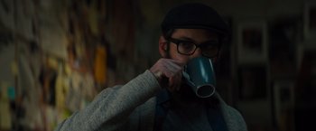 Movie still from “Samaritan” (2022), directed by Julius Avery – A man drinking from a blue mug with a hat on; Close Up shot, Over the shoulder angle