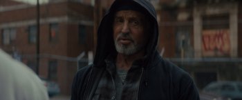 Movie still from “Samaritan” (2022), directed by Julius Avery – An older man wearing a black hooded jacket; Close Up shot, Low angle