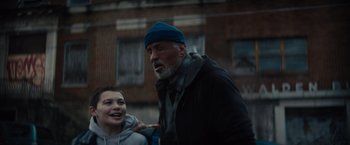 Movie still from “Samaritan” (2022), directed by Julius Avery – An older man and a young boy are walking together; Medium shot, Low angle