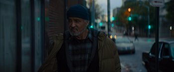 Movie still from “Samaritan” (2022), directed by Julius Avery – An older man wearing a blue hat and a jacket; Medium shot, Low angle