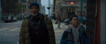 Movie still from “Samaritan” (2022), directed by Julius Avery – A man and a boy walking down a street; Medium shot, Low angle