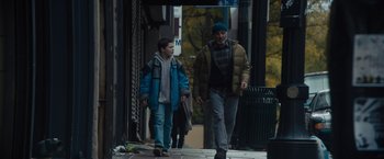 Movie still from “Samaritan” (2022), directed by Julius Avery – A man and a boy walking down a sidewalk; Wide shot, Low angle